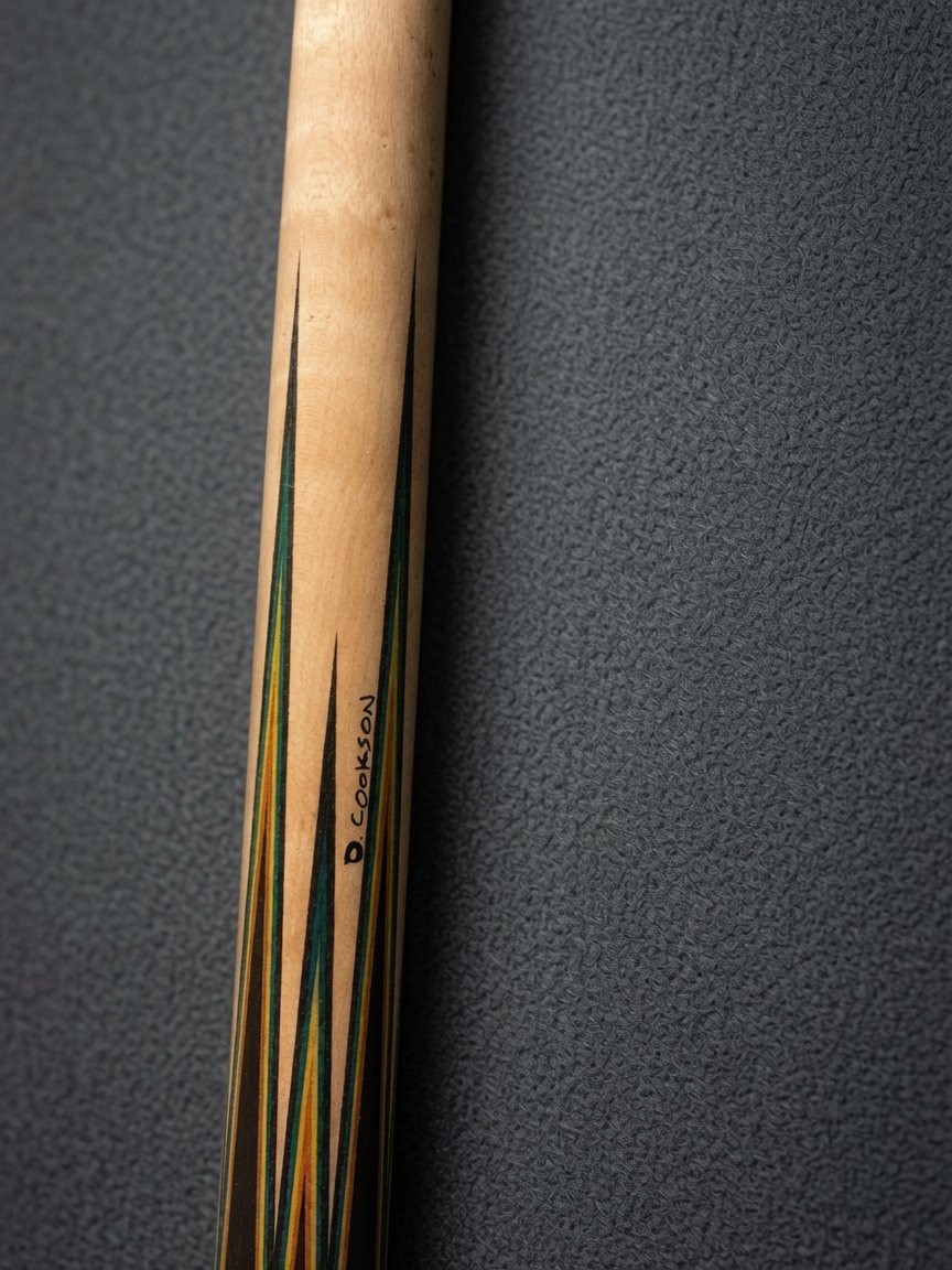Signed Cookson cue with green and orange points, angled view